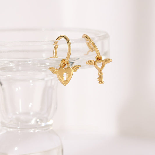<div id="offer-template-0">These 18K gold plated stainless steel earrings are the cutest addition to your jewelry collection. These earrings have detachable charms that you can interchange with other SOCALI charms. Cute angel wing detailing on the lock and key. </div> <div></div> <div> <p>Material: 18K Gold Plated Stainless Steel</p> </div>